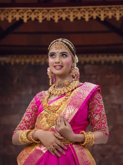 This shot captures the regal feel of the look, with the bride looking upwards. The lighting highlights the beautiful shimmer on her skin and the intricate details of her jewellery.