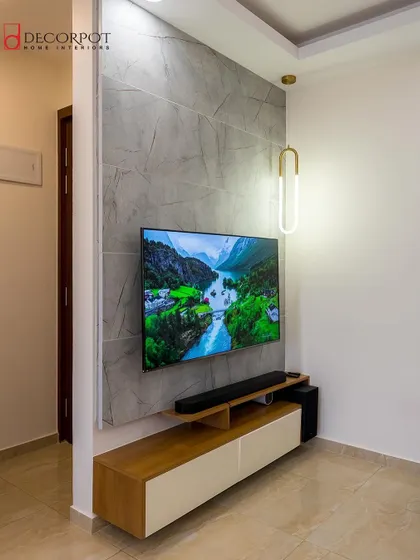 A compact and modern TV unit solution, perfect for a narrow wall. The design features a simple console and a textured grey back panel, accented by a stylish pendant light.