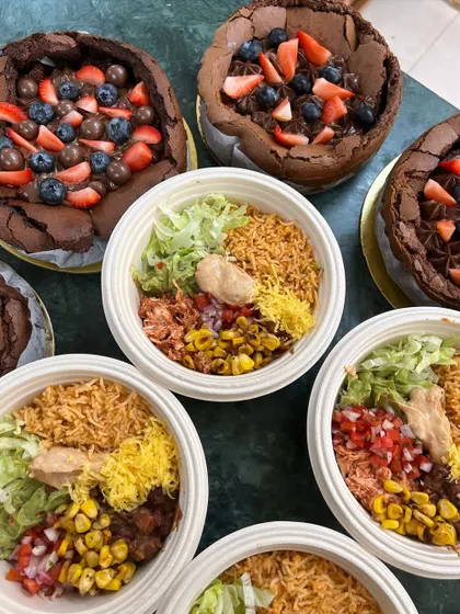 An overhead shot of some of our top-selling products: flourless chocolate cakes and Mexican rice bowls. A perfect combination of indulgent dessert and a hearty meal.