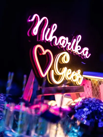 Personalization is key. A custom neon sign with the couple's names, Niharika and Geet, adds a modern, heartfelt touch to the bar area, ensuring their story is woven into every detail of the decor.
