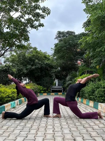 A synchronized Anjaneyasana (Crescent Lunge) with a friend. Practicing together helps align our energies and deepen our connection to the pose.