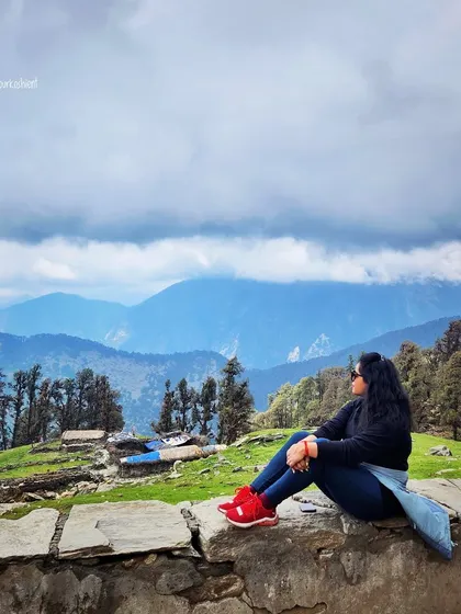 Taking in the breathtaking views of Tungnath. A simple dark sweater, jeans, and bright red shoes make for a comfortable and practical trekking outfit that still looks stylish.