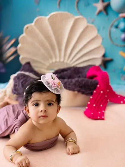 A different look from the mermaid session, with the baby wrapped in a simple cloth. This shows the versatility of a single themed setup.