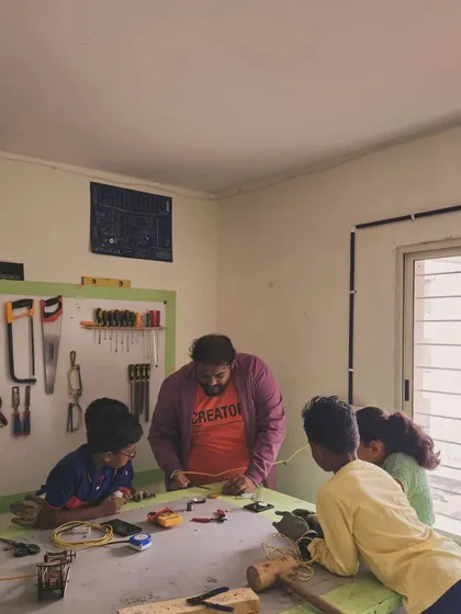 A typical day at the lab, with an instructor guiding a small group of students through a hands-on project.