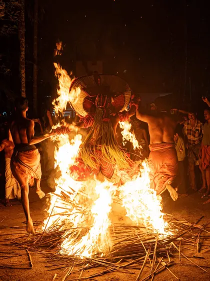 A sequence documenting the Kandanar Kelan Theyyam's fearless dance through fire. These images show the performer's complete surrender to the flames, a testament to the ritual's power.