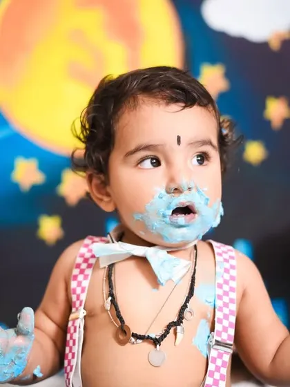 This little superhero is caught mid-snack during his fun cake smash. The blue frosting adds a pop of color against our starry night city backdrop.