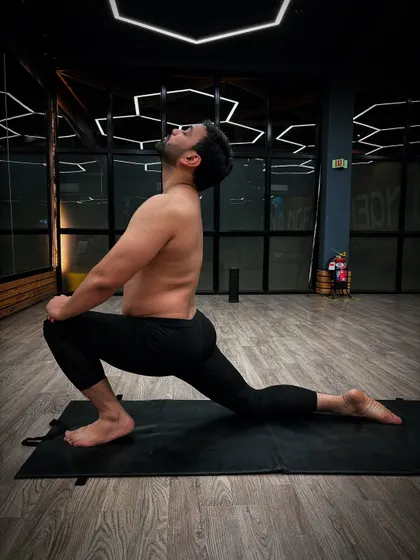 Performing Anjaneyasana (Low Lunge), a deep stretch for the hips and quadriceps. This pose is excellent for improving flexibility and balance.