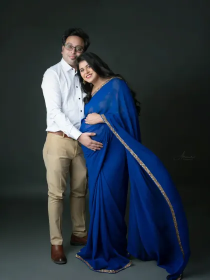A standing portrait that shows the beautiful connection between the couple. The flowing blue saree adds a touch of grace and movement.