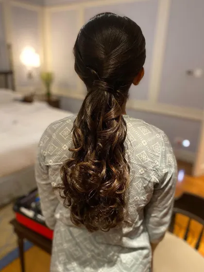 A sleek and simple ponytail with a twisted base and curled ends. This is a polished and sophisticated look for any formal event.