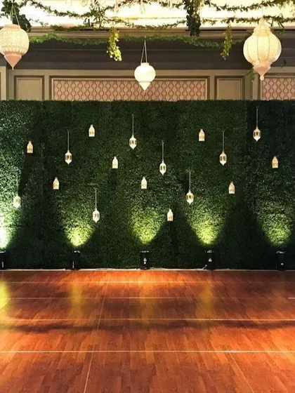 A full shot of the stunning green wall backdrop on a polished wooden floor. This setup is perfect for creating a memorable stage or photo zone at any high-end event.