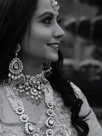 A classic black and white profile of the bride, highlighting her intricate jewelry and radiant smile. This timeless style emphasizes her beauty and elegance.