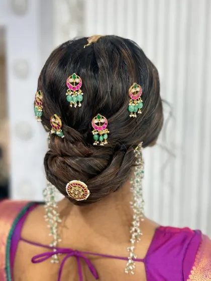 A beautiful textured bun decorated with multiple pieces of traditional temple jewellery, creating a very royal and intricate look.