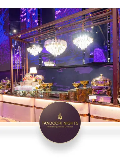 A stunning buffet setup under magnificent chandeliers, showcasing our use of premium serveware and lighting to create a truly high-end dining experience for corporate galas and receptions.