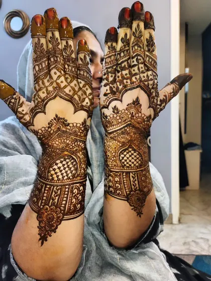 A lovely pose showcasing the back of the hands, featuring archway patterns popular in bridal designs.