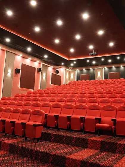 A wide shot of a massive, 147-seat private Dolby cinema I completed in Coimbatore, featuring stadium-style seating with vibrant red chairs.