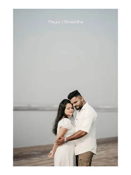 A wide-angle shot of the couple by the sea, creating a sense of peace and solitude. The text overlay adds a personalized touch.