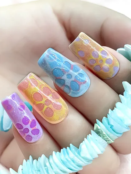 A beautiful 3D floral nail art design with a unique, bubbly texture. The pastel colors and glitter accents make this a soft and dreamy look.
