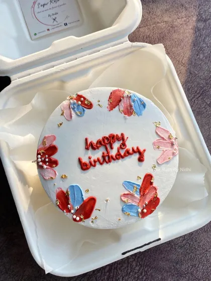 Another look at this beautiful hand-painted bento cake. The combination of red, pink, and blue creates a vibrant and cheerful design.