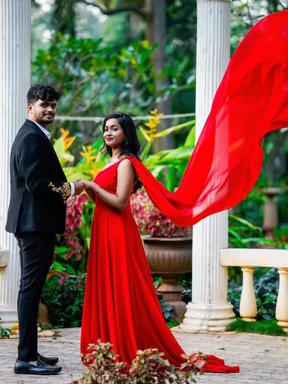 An elegant portrait in a white colonnade, with the bride's red dress providing a beautiful pop of color.