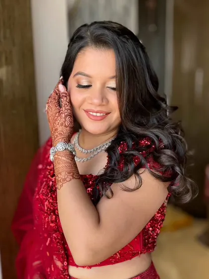 The soft curls and radiant makeup create a look that is both elegant and party-ready.