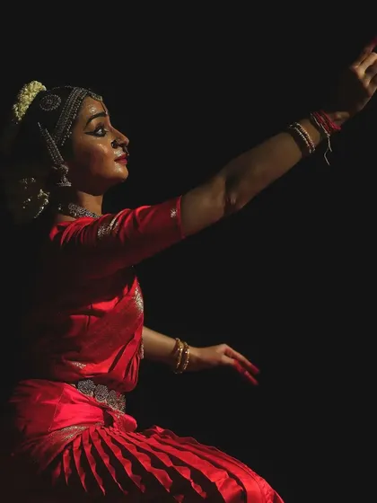 A dramatic pose captured with side lighting, emphasizing the lines and form of the body. This is from a pure dance sequence within the "Venkatesha Shreesha" production.