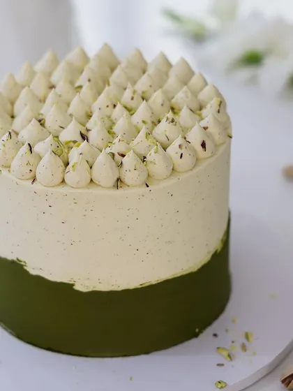 We craft a uniquely sophisticated flavor profile with our pistachio custard cake. The subtle green hue and piped cream topping create an elegant and understated design, perfect for celebrating Mother's Day with a gourmet touch.