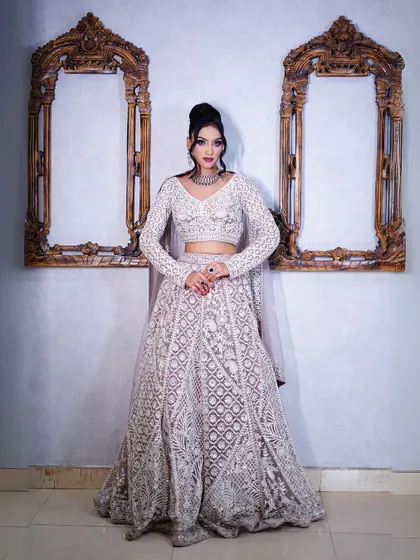 A full-length shot of the pastel lavender lehenga against a classic studio backdrop.