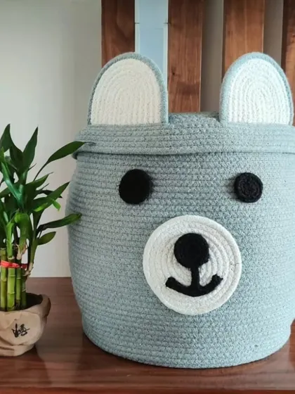 This grey bear-themed rope basket is a cute and practical storage solution. Sized at 12x16 inches, it's ideal for organizing toys or as a laundry hamper in a nursery.
