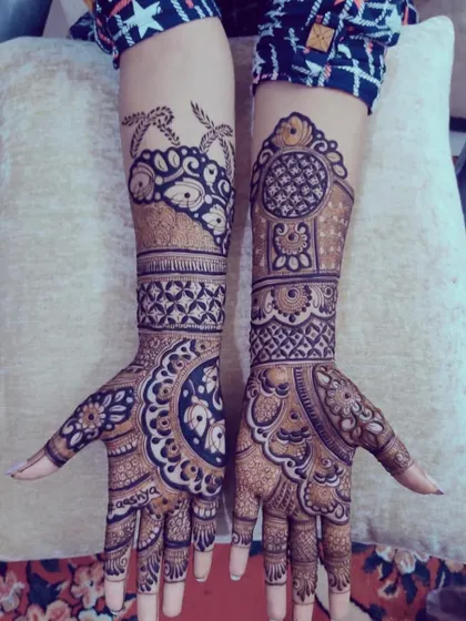 A bold and beautiful design featuring large circular mandalas on the palms, complemented by intricate patterns extending up the arms.