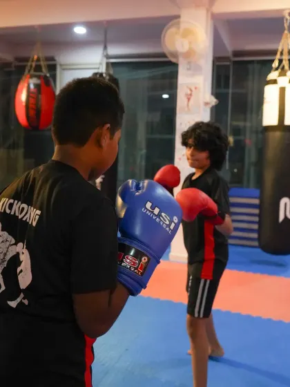 Two young boxers face off during a training drill. The intensity and focus in their eyes show the dedication they bring to every class, learning the art of boxing from the ground up.