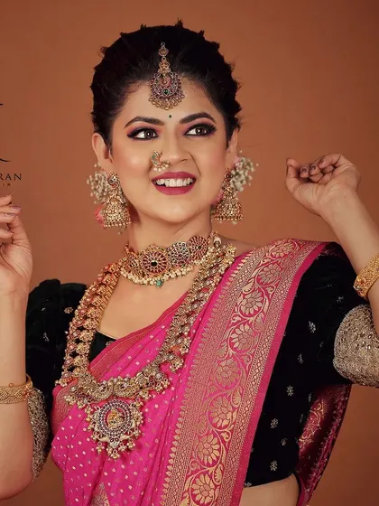 This bride looks stunning in a pink saree and a beautiful antique gold jewellery set. The peacock motifs on the choker and haram are a classic design element.