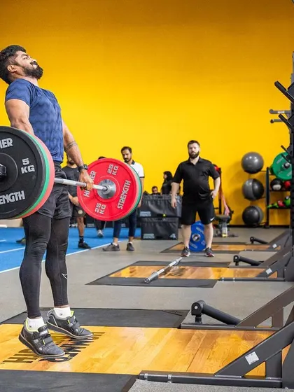 A powerful clean pull during a weightlifting session, building explosive strength from the ground up.