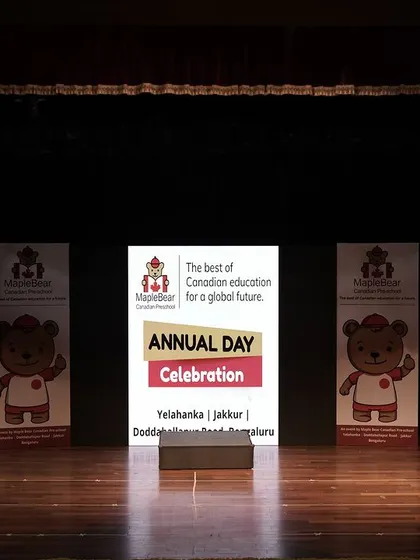 The stage is set and ready for the Maple Bear Annual Day Celebration. This image shows the clean, professional setup with branded standees and a central screen before the performances begin.