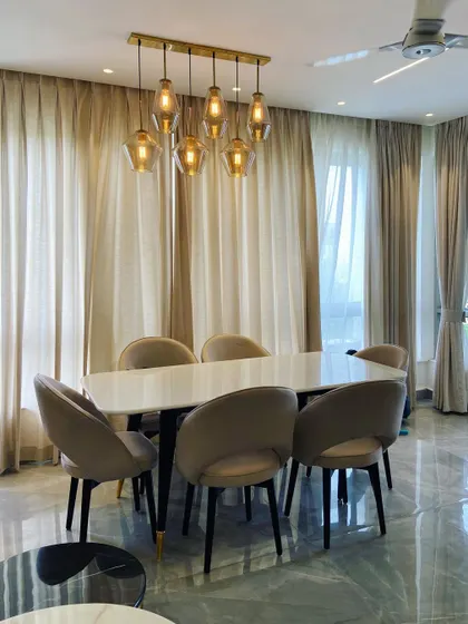 The warm glow from the pendant lights creates an inviting atmosphere for evening meals in this elegant dining space.