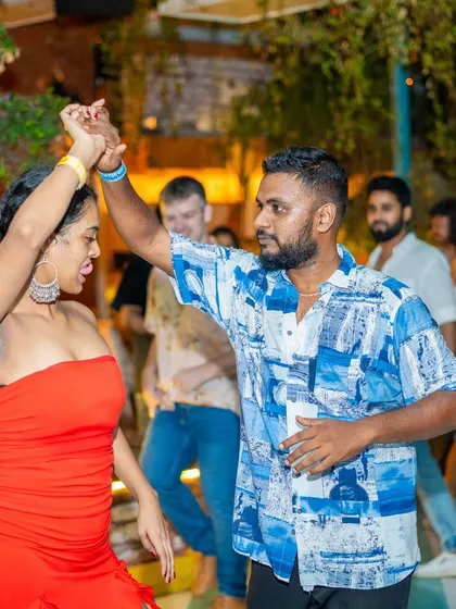 A passionate and energetic couple owning the dance floor. The vibrant outfits match the lively atmosphere.