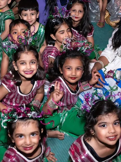 A group of girls in their performance costumes smile for the camera, their faces full of excitement and friendship.
