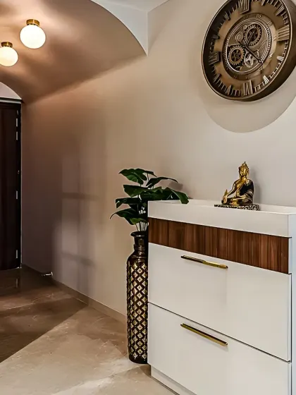 We designed this compact entryway with a modern two-tone shoe cabinet in white and wood. The simple, clean-lined unit provides ample shoe storage while serving as a beautiful console for decorative items.