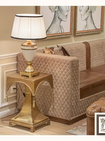 This contemporary metal side table offers a touch of modern glamour. The gold-finished frame with its unique curved design and decorative tassels makes it a chic and stylish accent piece.