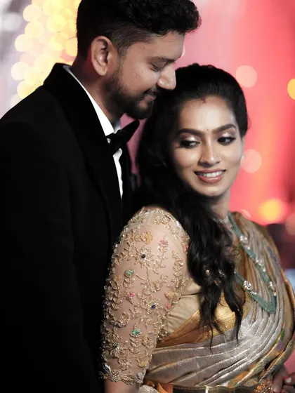 A beautiful shot of this happy couple. The client's custom-designed blouse and saree are a perfect choice for a modern and elegant reception.