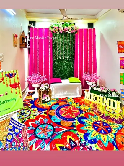 A wide view of the entire Mehendi/Dholki setup, showing how I can transform a room into a vibrant celebration space with a colorful carpet, backdrop, and props.