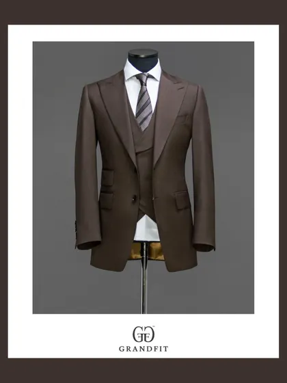 This bespoke three-piece suit in a rich brown fabric demonstrates true versatility. The addition of a matching waistcoat provides a layer of sophistication, making it an impeccable choice for business or formal occasions.