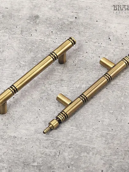 The Vivaldi cabinet handle in an Antique Brass finish. Its clean, cylindrical form is accented with subtle dark rings, adding a touch of visual interest to a minimalist design. Perfect for refreshing any modern kitchen or bathroom.
