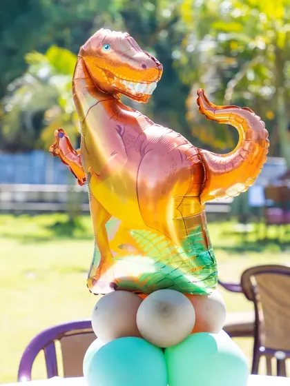 A T-Rex foil balloon centerpiece on one of the guest tables.
