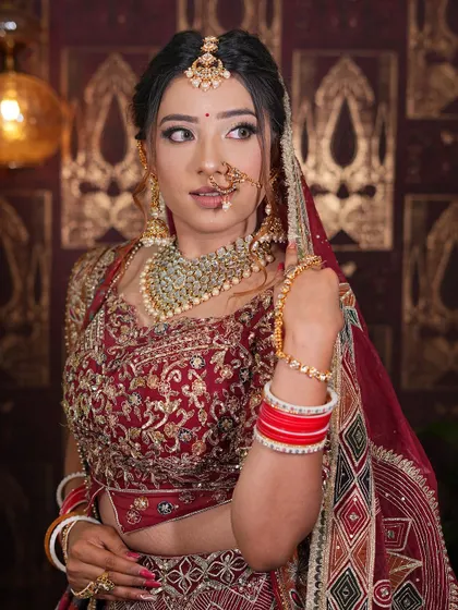 A close-up portrait of a bride in our maroon lehenga, highlighting the detailed blouse and dupatta work.