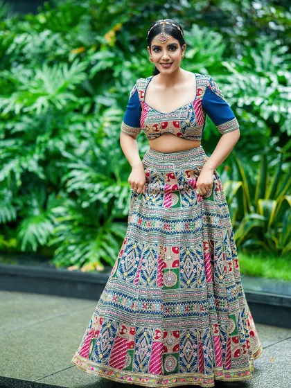 The model adjusts her lehenga, creating a natural and engaging moment. This style of shot adds a candid feel to a fashion portfolio.