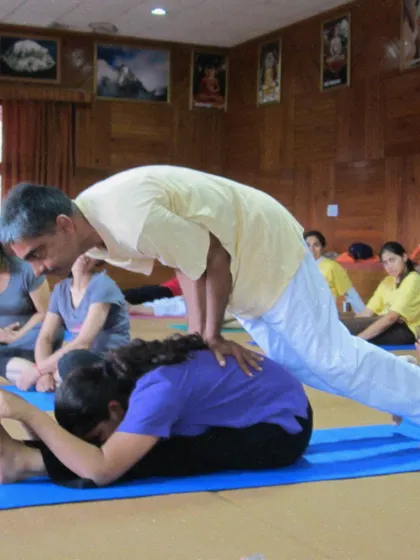 A throwback to a TTC from 2011, where a teacher assists a student in Paschimottanasana, the seated forward bend. Our lineage of teaching has a long and rich history.