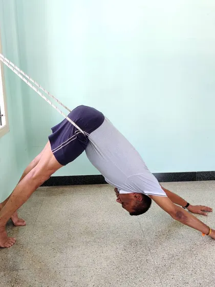 Another view of Adho Mukha Shvanasana with rope assistance. Notice how the rope helps to shift the weight back towards the heels, deepening the stretch in the hamstrings and calves.