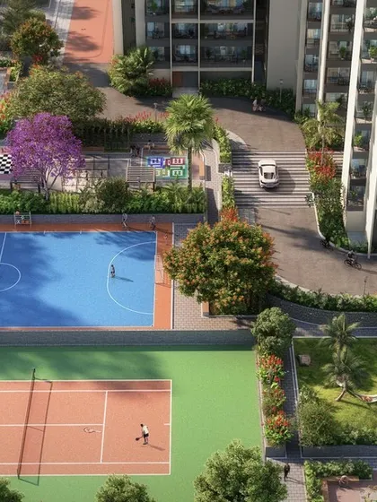 A comprehensive view of the sports facilities at Sattva Lumina, including tennis and basketball courts, surrounded by lush trees and flowering shrubs.