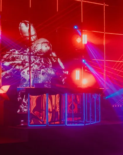 The DJ performing inside a custom-built cage, surrounded by a dynamic display of lights and visuals. This setup put the music and the performer at the heart of the event.