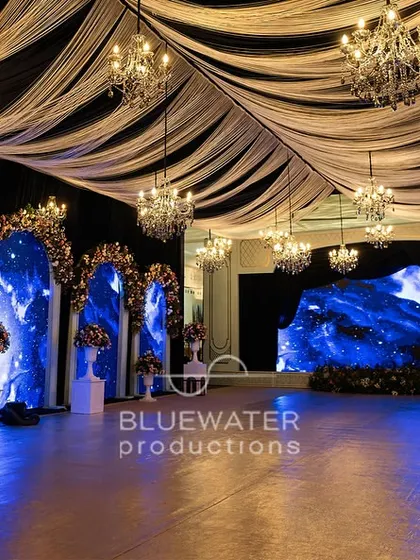 Inside the 'Blue Palace', where arched LED screens displaying a celestial night sky were flanked by classic columns and lush floral arrangements, creating a blend of modern tech and timeless romance.